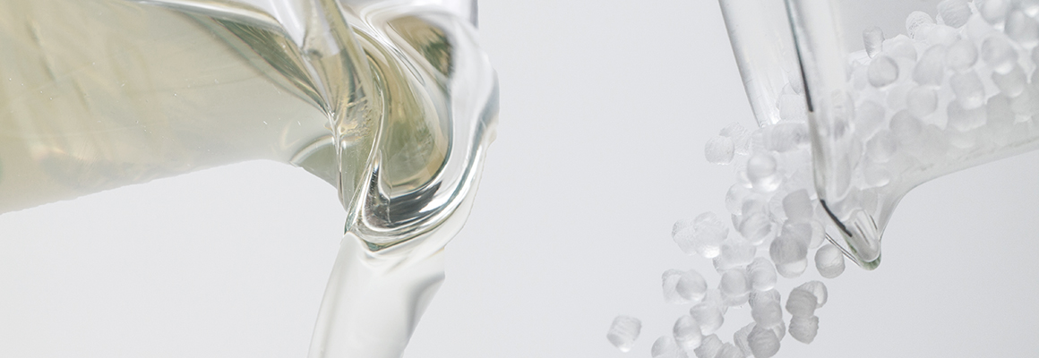 Viscosity modifiers pouring out of two laboratory beakers.