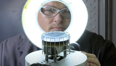 Worker rating engine part / piston using round light.