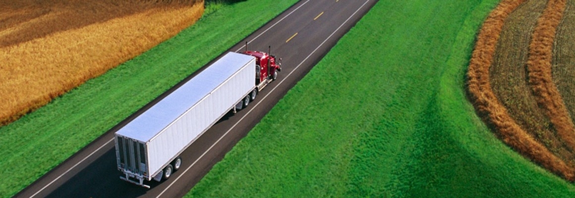 Heavy-duty semi truck driving down rural highway.